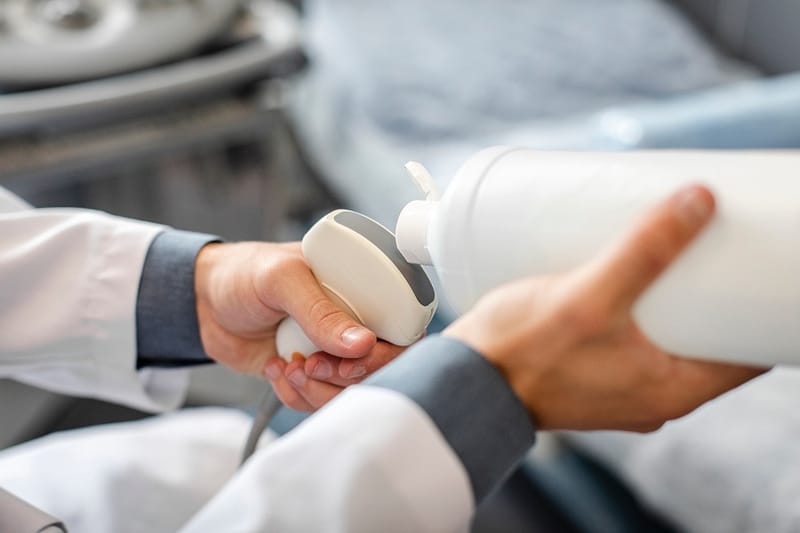 A doctor using handheld ultrasound equipment